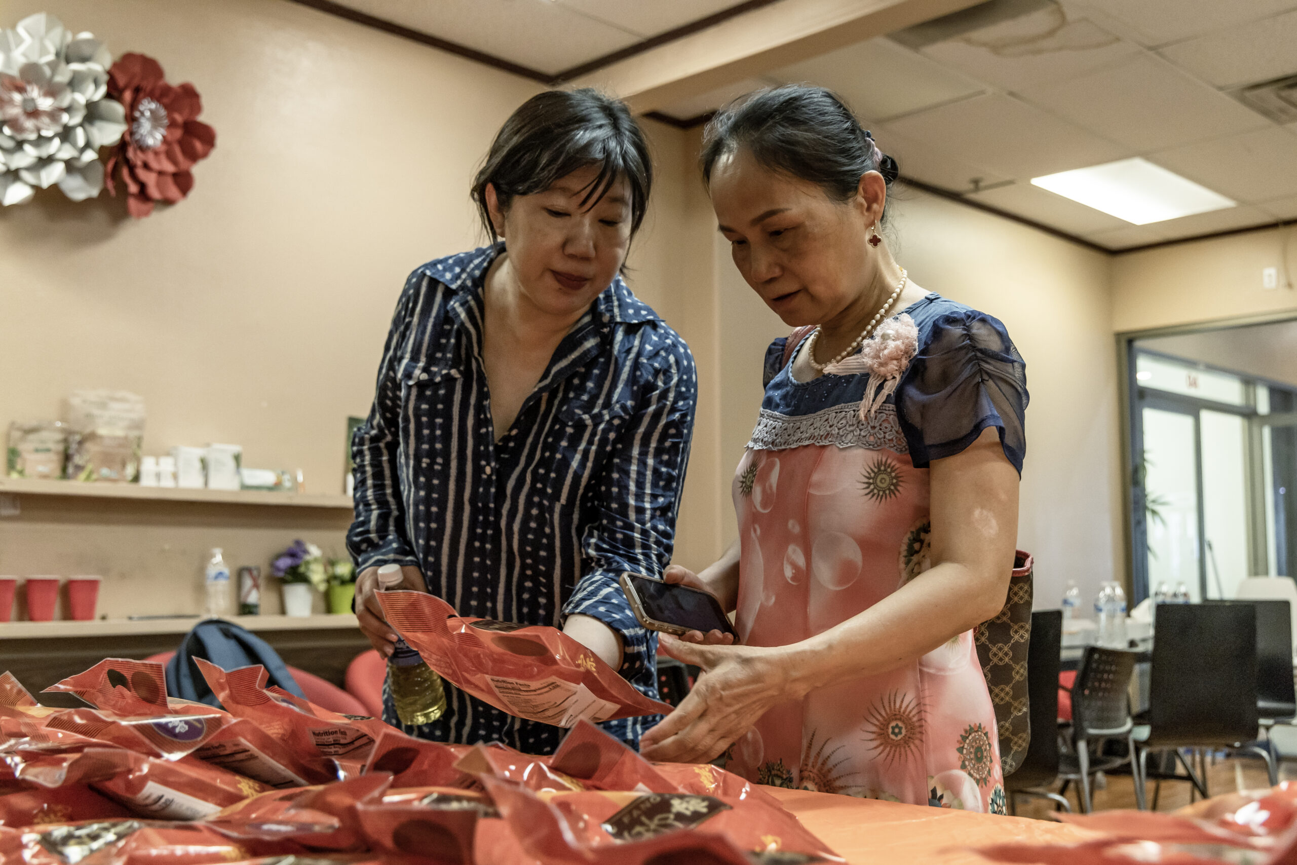 Nevada Chinese Association President Jenny Koo, left, sorts packages of zongzi, a rice dish wrapped in bamboo leaves, with Las Vegas resident Sheli Lu during the Dragon Boat Festival in Las Vegas, on Wednesday, June 5, 2024. (Photo by Christopher Lomahquahu/News21)