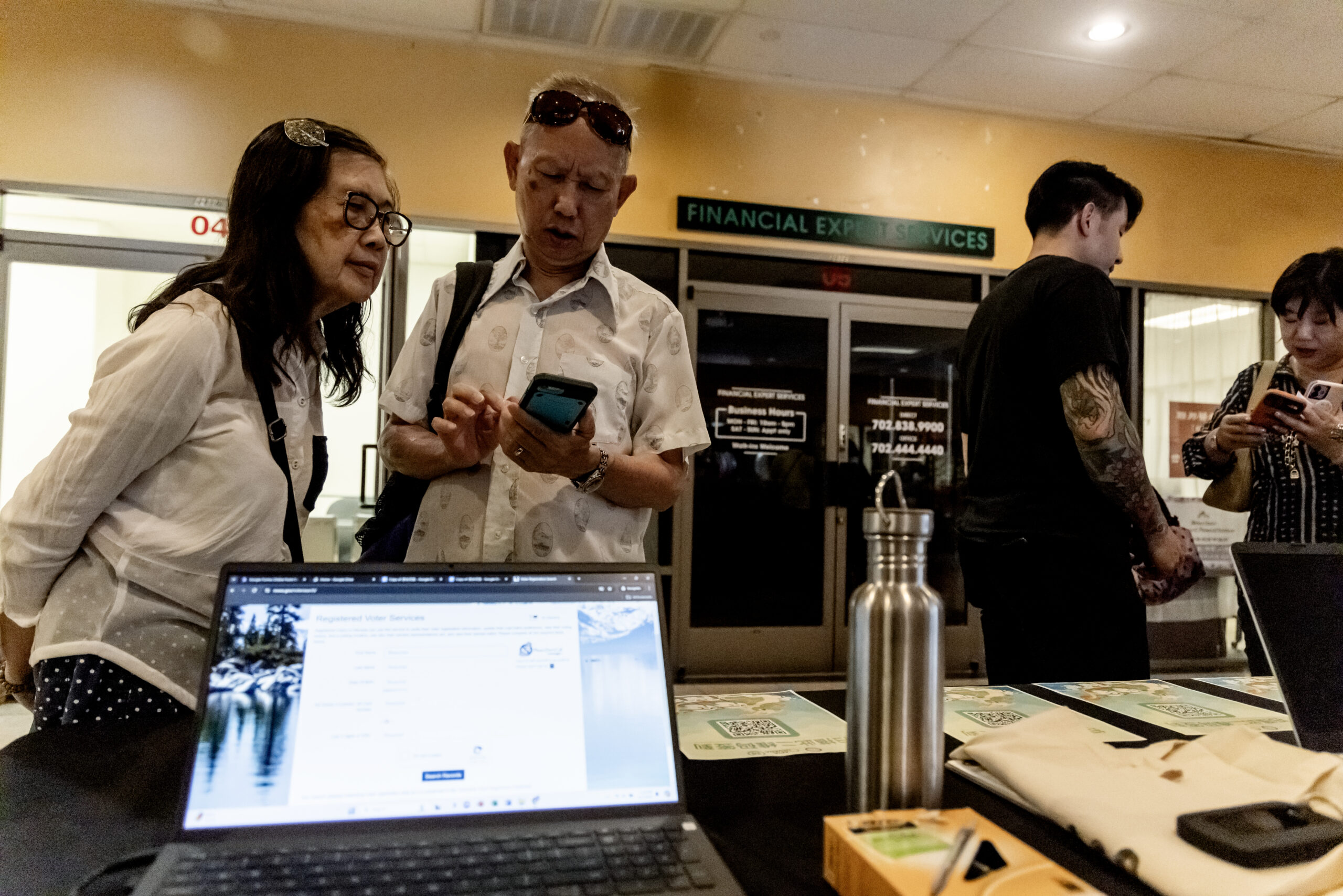 Members of the Las Vegas Asian community scan a QR code taking them to voter information translated into Chinese during the annual Dragon Boat Festival in Las Vegas on Wednesday, June 5, 2024. (Photo by Christopher Lomahquahu/News21)