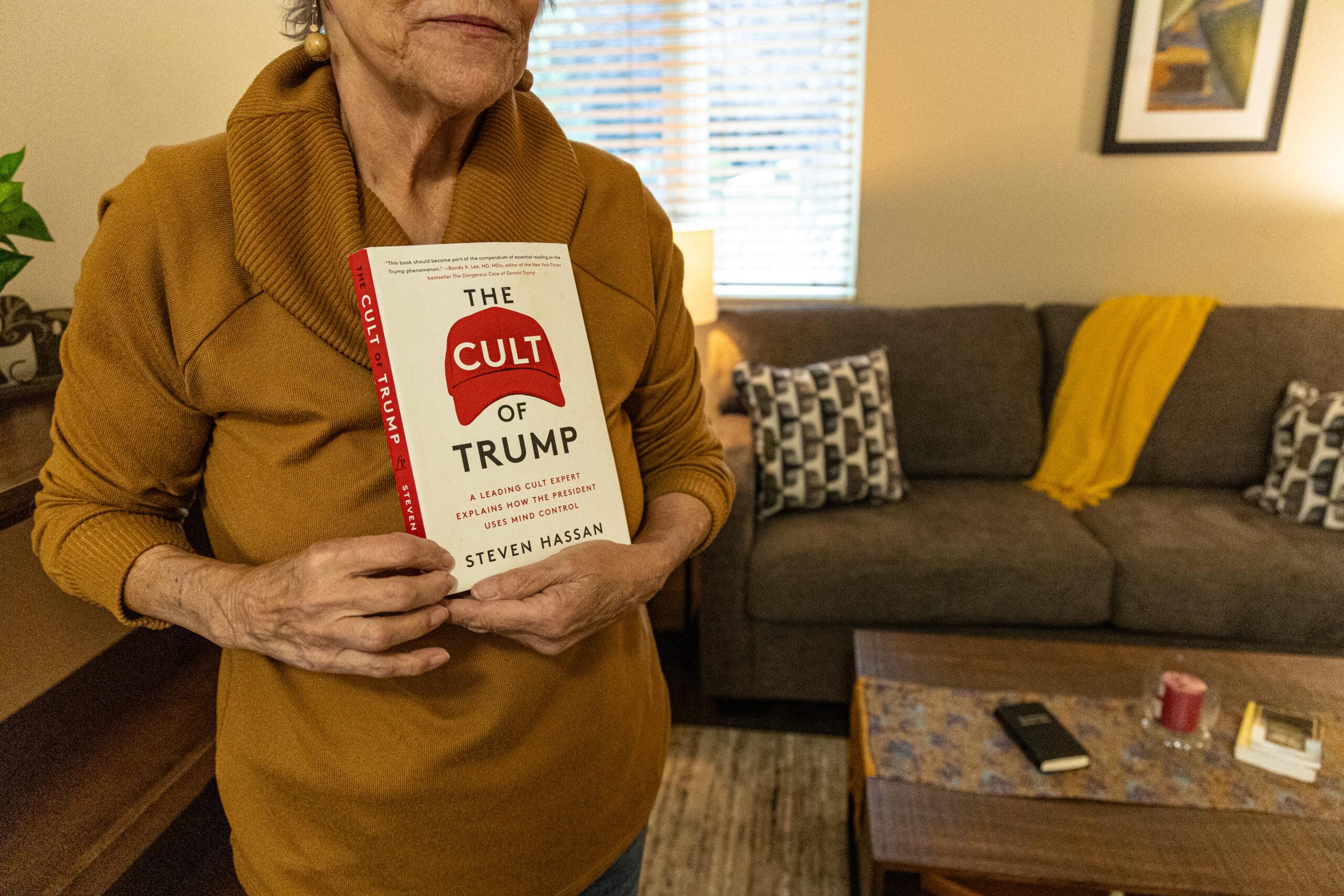 Pamela Hemphill, inside her apartment in Boise, Idaho, on June 17, 2024, holds one of the many books she read after the attack at the U.S. Capitol. (Photo by Donovan Johnson/News21).