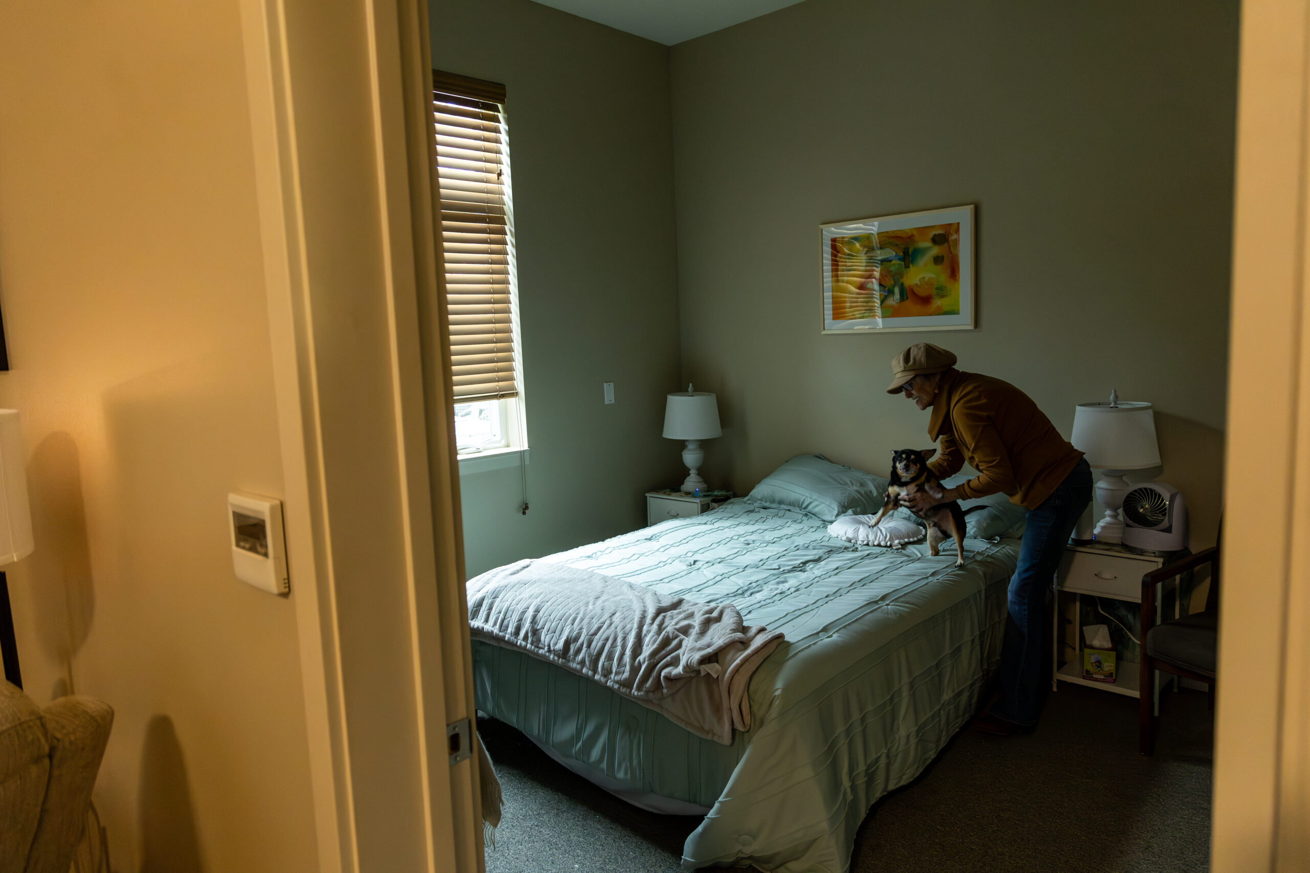 Pamela Hemphill holds her dog, Pork Chop, inside her apartment in Boise, Idaho, on June 17, 2024. Hemphill served two months in prison for her actions at the Capitol insurrection and has since become an outspoken critic of former President Donald Trump. (Photo by Donovan Johnson/News21)