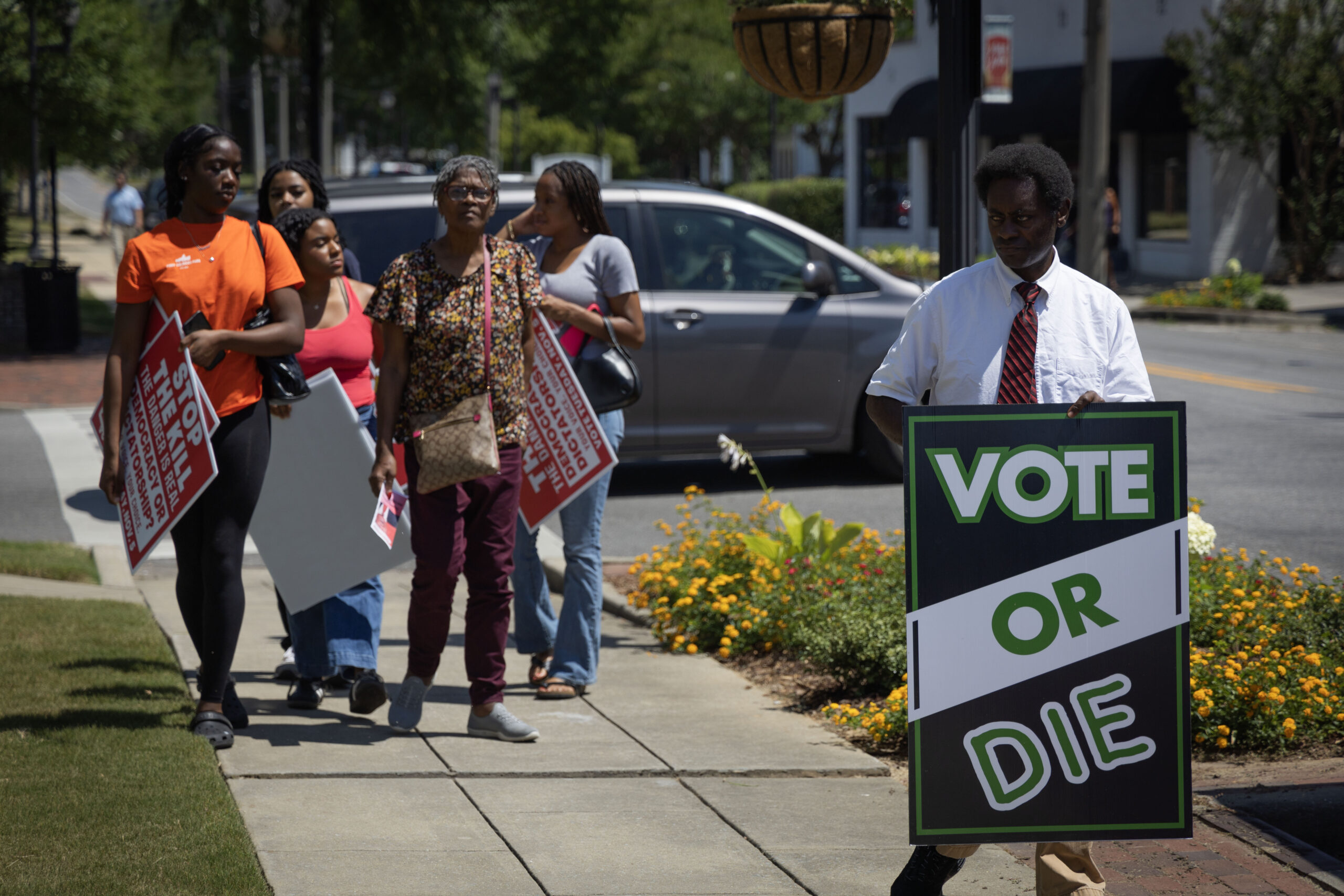 Carrying signs encouraging people to vote, attendees arrive at the Shelby Summit in Columbiana, Ala., on June 21, 2024. The event is an annual commemoration of Shelby County v. Holder, a 2013 Supreme Court case that found a section of the Voting Rights Act of 1965 to be unconstitutional. (Photo by Jordan Moore/News21)